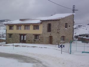 ein großes Steinhaus mit Schnee auf dem Boden in der Unterkunft Cases Ruralmorella in Morella