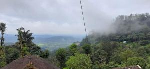 a view of a mountain with clouds in the sky at Spinson Home Stay in Madikeri +2 photos