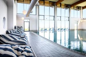 einen Pool mit 2 Betten in einem Gebäude mit Fenstern in der Unterkunft TUI BLUE Sylt in Rantum