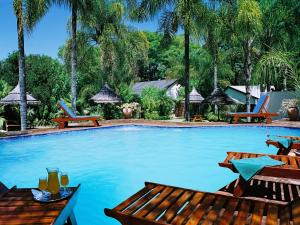 a swimming pool with tables and chairs in a resort at Karula Hotel in White River
