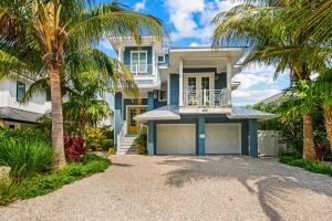 a house with palm trees in front of it at Endless Summer in Anna Maria