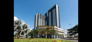 a tall building with palm trees in front of it at Humaira - Metropol in Bukit Mertajam
