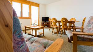 a living room with a couch and a table and chairs at Christiania in Riederalp