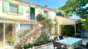 a table and chairs in front of a house at Rendez-vous en Provence -10 personnes- duo de gîtes- piscine privée - clim in Cheval-Blanc