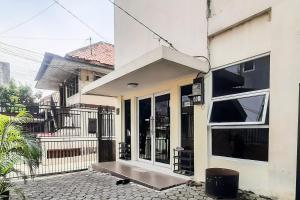 a house with a large glass door with a porch at RedDoorz Syariah Near Transmart Mall Palembang in Palembang