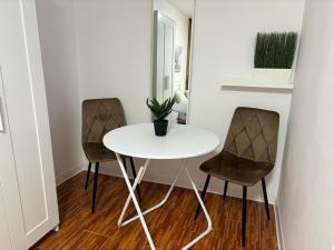 a small white table and two chairs in a room at One Room Apartment Ptm 3 in Bucharest +10 photos