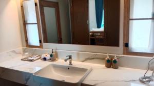 a bathroom with a sink and a large mirror at Koh Mook Sivalai Beach Resort in Ko Mook