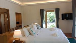 a bedroom with a large white bed with a window at Koh Mook Sivalai Beach Resort in Ko Mook