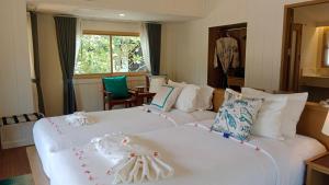 two beds in a hotel room with white sheets at Koh Mook Sivalai Beach Resort in Ko Mook