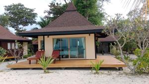 a small house with two chairs on a deck at Koh Mook Sivalai Beach Resort in Ko Mook