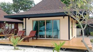 a screened in porch with two chairs on a deck at Koh Mook Sivalai Beach Resort in Ko Mook