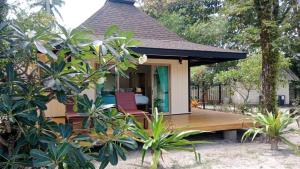 a house with a wooden deck and chairs on it at Koh Mook Sivalai Beach Resort in Ko Mook