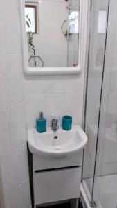 un bagno con lavandino e specchio di Stay Inn Apartments a Bucarest Altre 23 foto