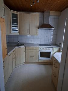 a kitchen with white cabinets and a stove top oven at Ferienwohnung Unterm Tierstein in Bad Ditzenbach
