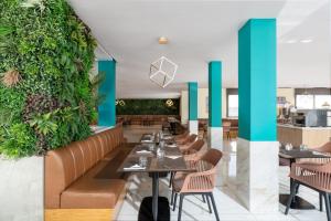 un restaurant avec des tables et des chaises et un mur vert dans l'établissement Rihab Hotel, à Rabat