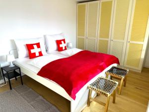 a bedroom with a large bed with a red blanket at SwissHut Stunning Views Alps & Lake - Chalet Schärme in Sigriswil +23 photos