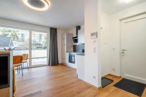 a kitchen and living room with a large window at Modernes Studio mit sonniger Dachterrasse in Telfs