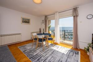 a living room with a table and chairs and a large window at Atemberaubendes Apartment direkt am Meer gelegen mit Meerblick, Klima, WiFi in Novi Vinodolski +25 photos