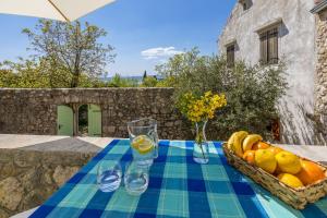 einen Tisch mit einem Obstkorb und einer Blumenvase in der Unterkunft Einzigartiges mediterranes Steinhaus mit Meerblick, Chillout-Bereich, Bike, BBQ, WiFi in Grižane