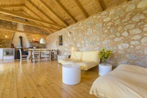 ein Wohnzimmer mit einer Steinwand und einer Couch in der Unterkunft Einzigartiges mediterranes Steinhaus mit Meerblick, Chillout-Bereich, Bike, BBQ, WiFi in Grižane