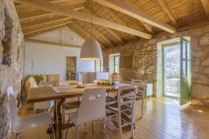 eine Küche und ein Esszimmer mit Tisch und Stühlen in der Unterkunft Einzigartiges mediterranes Steinhaus mit Meerblick, Chillout-Bereich, Bike, BBQ, WiFi in Grižane
