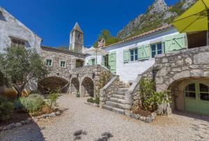 ein Haus mit einem Steingebäude mit einem Turm in der Unterkunft Einzigartiges mediterranes Steinhaus mit Meerblick, Chillout-Bereich, Bike, BBQ, WiFi in Grižane + 32 Fotos