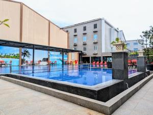 a swimming pool at a hotel with a building in the background at MAXONE Dumai in Dumai