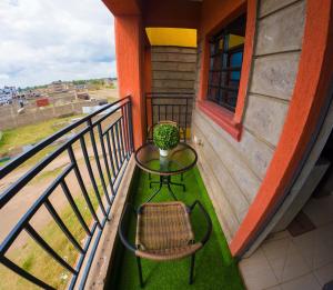 a balcony with a table and a chair on it at Brightstay furnished apartments in Nairobi