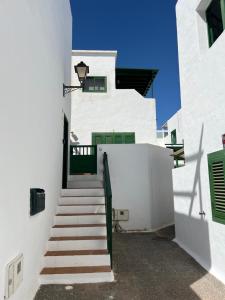a stairway leading up to a white building with green doors at Apartment Sonrisa - spacious two bedroom apartment in Costa Teguise