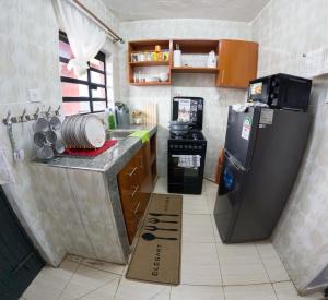 a small kitchen with a refrigerator and a counter at Brightstay furnished apartments in Nairobi