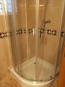 a shower with a glass door in a bathroom at Playa del Cura apartment with a free parking place in Torrevieja