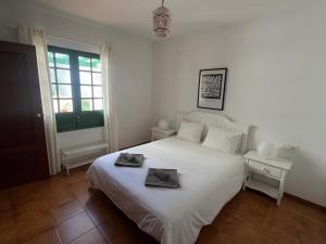 a bedroom with a white bed with two towels on it at Apartment Sonrisa - spacious two bedroom apartment in Costa Teguise
