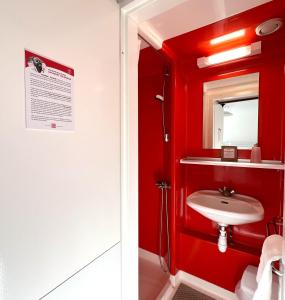 een rode badkamer met een wastafel en een spiegel bij Hôtel Club Le 1850 Risoul in Risoul +32 foto's