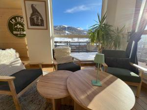 a living room with a table and chairs and a window at Hôtel Club Le 1850 Risoul in Risoul