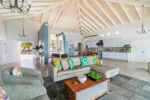 a living room with two couches and a kitchen at Breakwaters on Pezula in Knysna