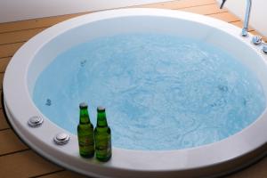 three bottles of beer sitting in a bath tub at MIRATIO Sauna Onna in Onna