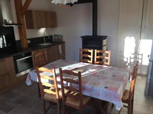 a kitchen with a table with chairs and a stove at Gîte des lacs et cascades in Bonlieu