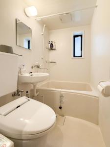 a white bathroom with a toilet and a sink at 鶴見101 地铁站徒步5分 Free wifi in Osaka
