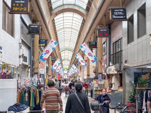 a group of people walking through a shopping mall at 鶴見101 地铁站徒步5分 Free wifi in Osaka