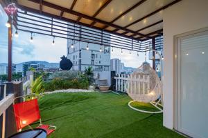 a balcony with green grass and a hammock at Pome' Coffee & Homestay in Da Nang