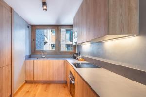 a kitchen with wooden cabinets and a sink and a window at ISARD HOMES & SPA BY SELECT RENTALS in El Tarter +20 photos