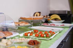 a buffet with many plates of food on a table at HOTIDAY Room Collection - Roma Barberini in Rome