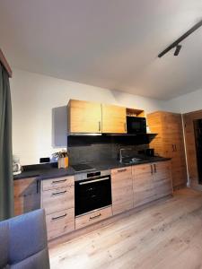 a kitchen with wooden cabinets and a stove top oven at Schaidreithof in Grossarl +118 photos