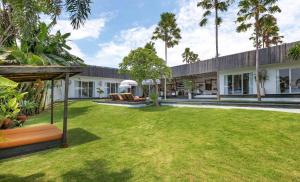 una vista esterna di una casa con cortile di Villa Ikebana - Trendy 5BR Spacious Villa with Rice Field Views, Large Pool, and 5 Minutes to Canggu a Kerobokan