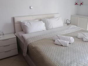 a white bed with white pillows on top of it at Elite Home in Polykastro