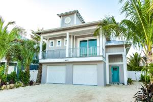 una casa con due porte da garage e palme di Freckled Fin ad Anna Maria