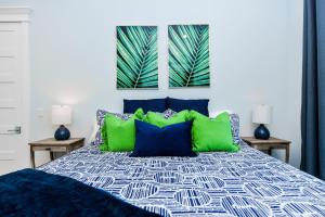 una camera da letto con un letto con cuscini verdi e blu di Freckled Fin ad Anna Maria Altre 36 foto