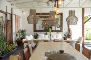 un soggiorno con un grande tavolo e sedie di Villa Ikebana - Trendy 5BR Spacious Villa with Rice Field Views, Large Pool, and 5 Minutes to Canggu a Kerobokan