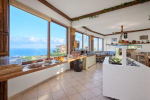 a kitchen with large windows and a view of the ocean at Spiros-Soula Family Hotel & Apartments in Agia Pelagia