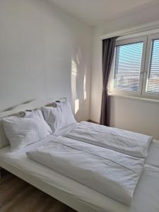 a white bed in a bedroom with a window at Ferienwohnung Mentenwirt Alp Lungau in Sankt Michael im Lungau